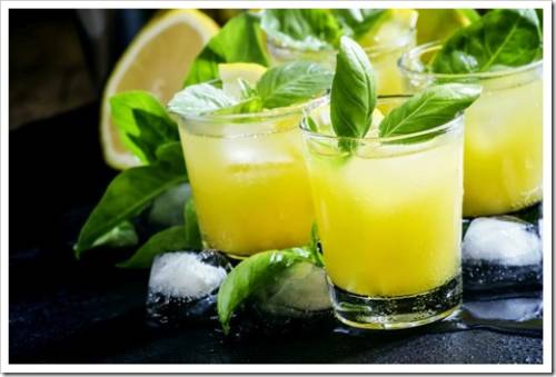 Alcoholic cocktail Basil smash with green basil, gin, sugar syrup, lemon juice and ice, black background, selective focus