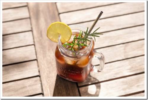 Cold brewed coffee as summer drink with ginger ale and rosemary in a mason glass for hot days